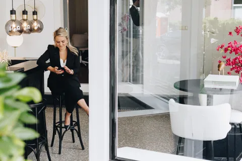 Zakelijke vrouw in stijlvol kantoorinterieur met designlampen