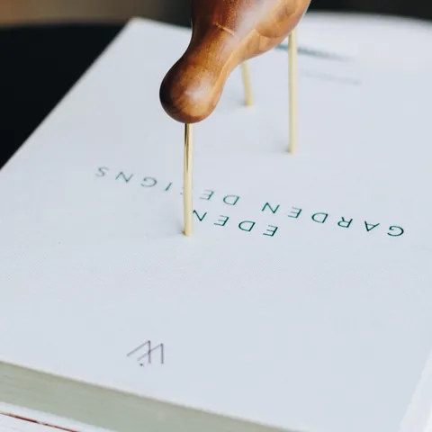 Close-up van een tuinontwerpboek met houten plantensteun op de omslag
