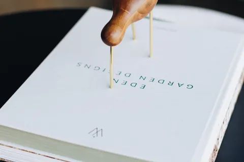 Close-up van een tuinontwerpboek met houten plantensteun op de omslag