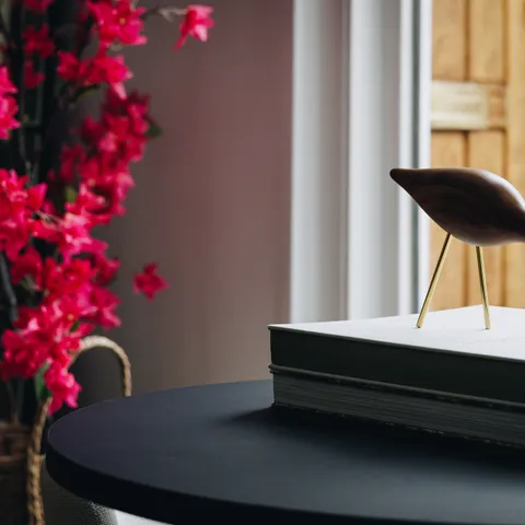 Stijlvolle kantoorruimte van LG Vastgoed met decoratieve kunst op een tafel naast een raam met uitzicht op de entree